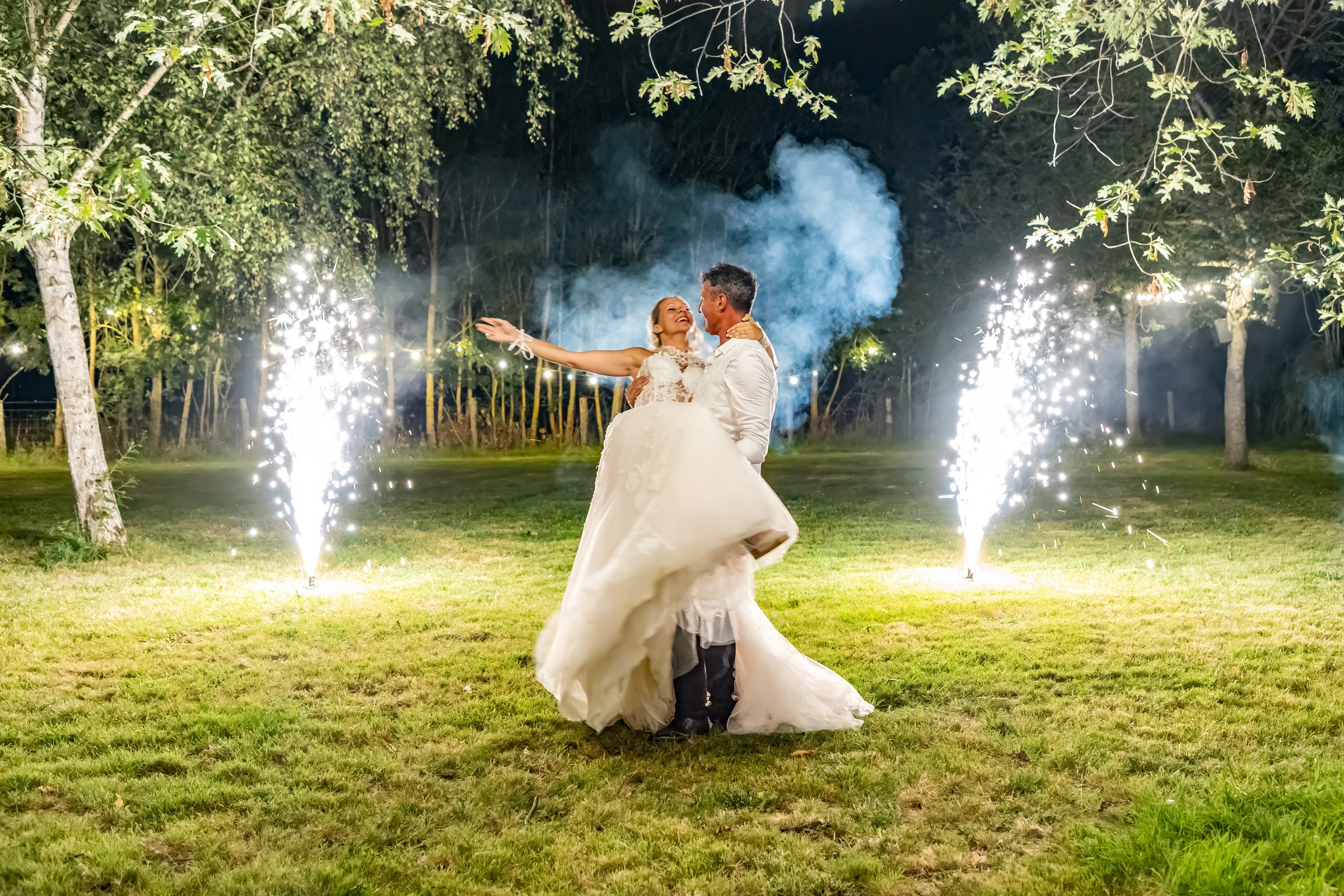 Photo mariage — les mariés dansent sous les gerbes d'étincelles