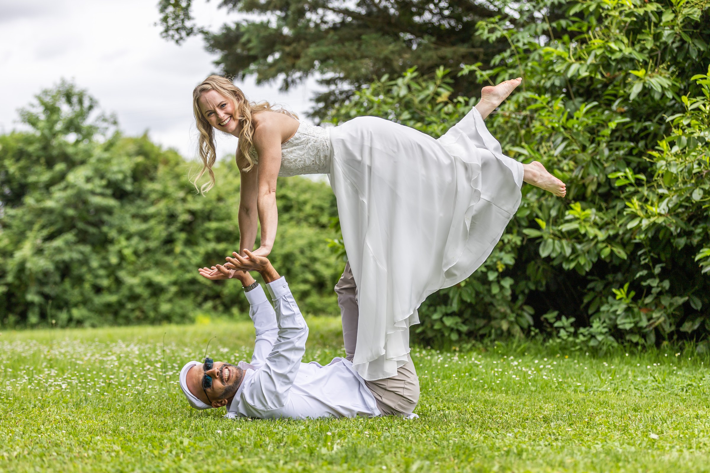 Photo mariage — les mariés, figure acrobatique sur l herbe